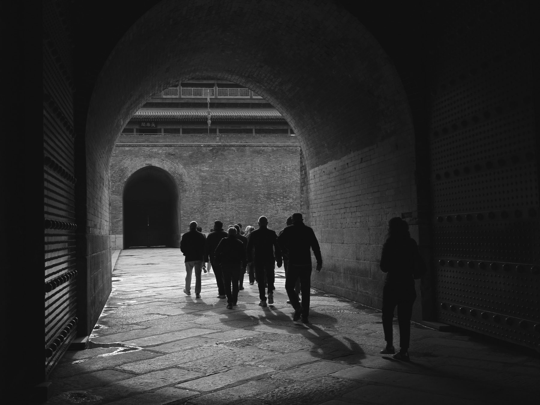 People walking through a historic city gate in China